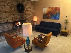 a living room filled with furniture and a fire place next to a wall mounted tv