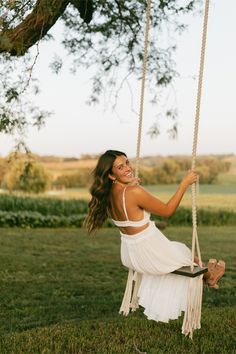 a woman sitting on a swing in the grass