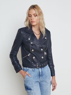 A biker-style blue leather jacket elevated by embossed silvertone buttons. Edgy-authentic details include an attached leather belt, zipper pockets and zipper trim, sleeve straps, and chunky belt with buckle. Fully lined. 100% Lambskin. *Slim fit through the arms, size up if you plan to layer* | L'AGENCE Billie Belted Leather Jacket In Midnight Long Sleeve Biker Jacket With Belt Loops, Fall Biker Leather Jacket With Belt Loops, Biker Style Belted Leather Jacket, Belted Biker Leather Jacket, Belted Moto Leather Jacket, Edgy Leather Biker Jacket With Belt Loops, Edgy Leather Belted Biker Jacket, Biker Jacket With Belt Loops, Trendy Leather Belted Biker Jacket