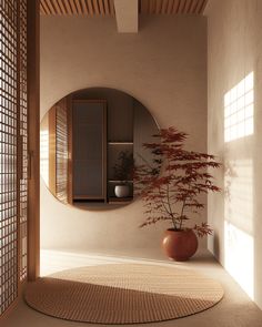 a round mirror sitting on the side of a wall next to a potted plant