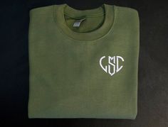 a green t - shirt with the letters gld on it and a white monogram