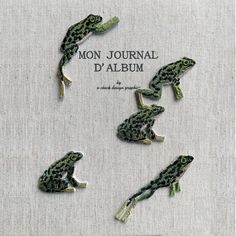 four green frog brooches sitting on top of a piece of cloth with the words mon journal d'album written below them