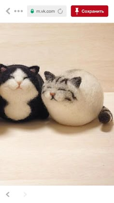 three stuffed animals are laying next to each other on a table, one cat is sleeping and the other has its eyes closed