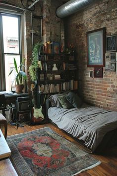 a bedroom with brick walls and lots of bookshelves on the wall, a bed in front of a window