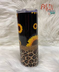 a black and leopard print tumbler with sunflowers painted on the side, sitting on a white furnishing