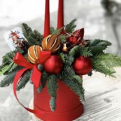 a red candle holder filled with christmas decorations