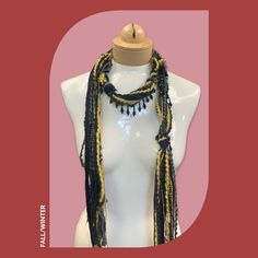 Discover this stunning bohemian beaded scarf necklace, crafted from luxurious Italian mohair yarn. The perfect lightweight accessory to elevate your holiday style. Features: Black and gold color combination Mohair yarn Italian craftsmanship Lightweight and comfortable Beaded details Linen gift pouch Benefits: Adds a touch of bohemian elegance to any outfit Perfect for the holiday season Luxurious and high-quality materials Versatile and can be worn in multiple ways Makes a thoughtful and stylish Bohemian Black Handmade Scarves, Bohemian Black Handmade Scarf, Elegant Gold Scarf One Size, Handwoven Black Beaded Necklace As Gift, Bohemian Winter Festive Scarves, Bohemian Winter Scarves For Festive Occasions, Handmade Elegant Scarves One Size, Handmade Yarn Bohemian Scarves, Handmade Bohemian Yarn Scarves