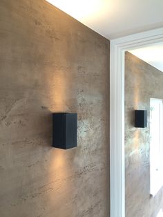 two black square lights mounted to the side of a wall