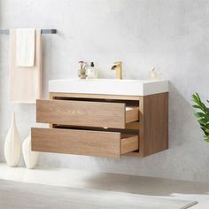 a bathroom with a sink, mirror and towel rack in it's corner next to a potted plant