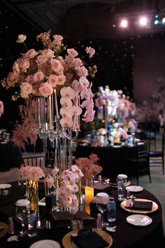 the centerpieces are filled with pink flowers and greenery in tall glass vases