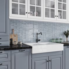 a kitchen with gray cabinets and black counter tops, white appliances and a sink in the center