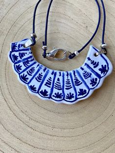 a blue and white necklace on a leather cord