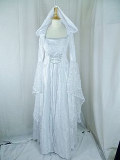 This dress will be made to the measurements that you send me. Please send me your bust, waist and hip measurements and please measure from the top of your shoulder to the floor with shoes on. It is made with beautiful white velvet and stunning heavy white bridal duchess with silver embroidered detailing. The sleeves are in part velvet with a lovely white embroidered organza. It has corset style front and back with lacing so you can adjust the dress to fit your body shape. Combined shipping on multiple items. If you purchase express shipping by courier please send me your phone number thank you. White Costume Dress With Fitted Bodice, Medieval Wedding Dress With Fitted Bodice, Fitted Floor-length Ball Gown For Wedding Night, Fitted Medieval Ball Gown For Wedding, Medieval White Dress With Fitted Bodice, Fitted Ball Gown Medieval Wedding Dress, Medieval Style White Wedding Dress, Elegant White Medieval Wedding Dress, Fitted White Gown For Costume