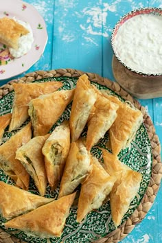 there are several pastries on the plate next to some dip and yogurt