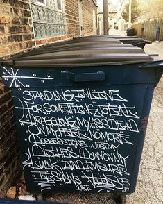 graffiti written on the side of a trash can