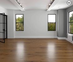 an empty room with three windows and wooden floors