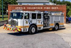 a fire truck is parked in front of an army volunteer fire department sign that reads,