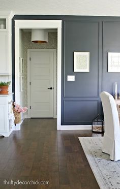 a dining room with blue walls and wooden floors