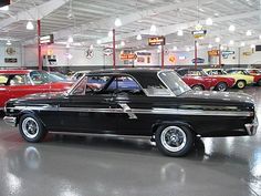 an old black car is parked in a garage