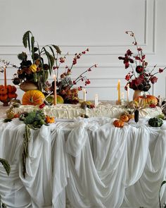 a table topped with lots of different types of flowers and fruit on top of it