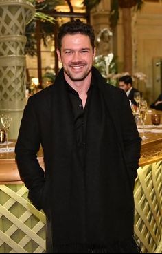 a man standing in front of a bar smiling at the camera