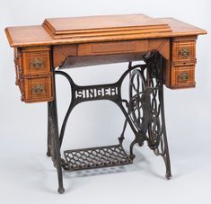 an antique sewing table with drawers and a machine on it's legs that is turned upside down