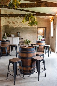 the inside of a restaurant with wooden barrels and stools