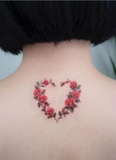 the back of a woman's neck with red flowers in the shape of a heart