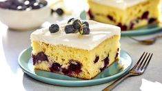 there is a piece of cake with blueberries on it and a fork next to it