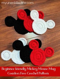 two crocheted mickey mouses sitting on top of a wooden floor