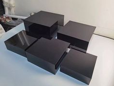 four black boxes sitting on top of a white table