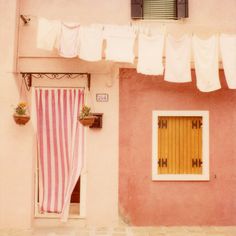 a pink house with some clothes hanging out to dry