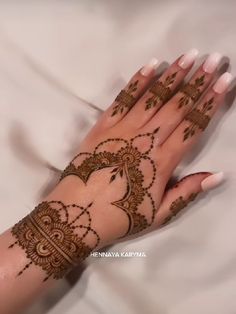 a woman's hand with henna tattoos on it