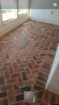 an empty room with brick floors and windows