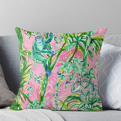 a pink and green pillow with monkeys in the jungle on it's back side