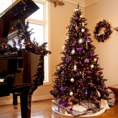 a decorated christmas tree sitting next to a piano