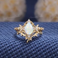 a close up of a ring on a blue cloth with gold trimmings and diamonds