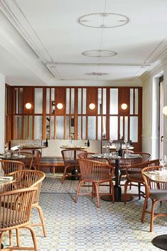 an empty restaurant with wooden chairs and tables