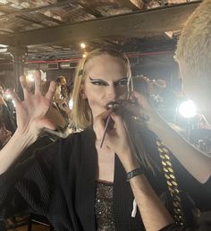 a woman is getting her make up done in front of the audience at a fashion show