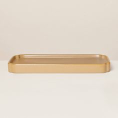 a gold rectangular tray sitting on top of a white table