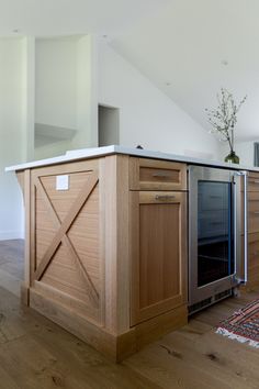 a kitchen with wooden cabinets and an island in the middle of the room, along with a rug on the floor