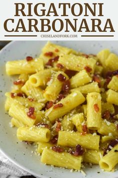 a white plate topped with rigatoni carbonara pasta and bacon covered in parmesan cheese