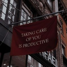 a red sign that says taking care of you is productive on the side of a building