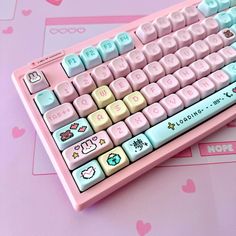 a pink keyboard with hello kitty stickers on it