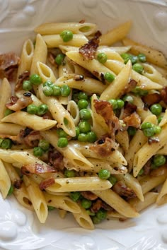 pasta with peas and bacon in a white bowl