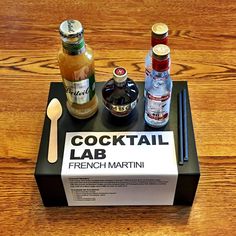 the contents of a cocktail bar sitting on top of a wooden table next to condiments