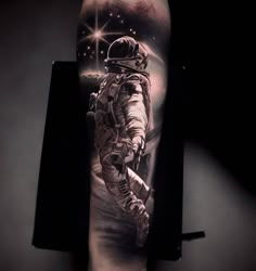 an astronaut tattoo on the arm