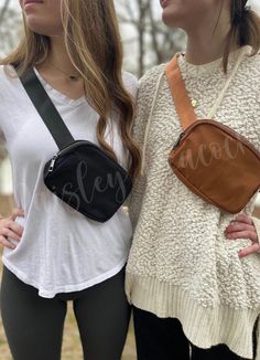 two women standing next to each other with their arms around each other and one holding a purse