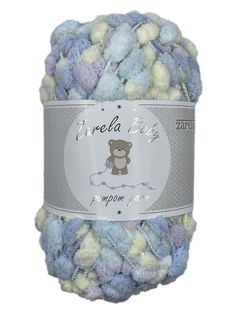 a ball of blue and white yarn with a teddy bear on the top, in front of