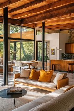 a living room filled with lots of furniture next to tall glass windows on the wall